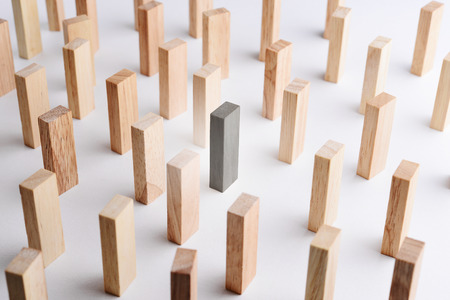 Black color wood block stand out from the crowd, metaphor to business concept of individual, unique, outstanding. Selective focus, gray background. の写真素材