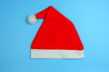 Red Christmas hat or Santa Claus hat on vintage blue background. Flat lay, top view, blank space. Decoration on happy new year concept. の写真素材