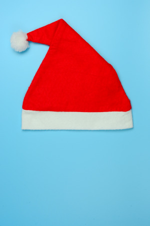 Red Christmas hat or Santa Claus hat on vintage blue background. Flat lay, top view, vertical, with blank space. Decoration on happy new year concept. の写真素材