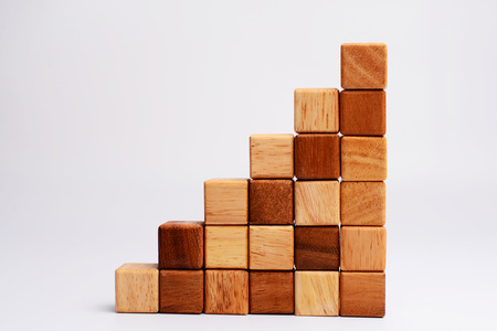 Stack of square wood block in statistics graph shape, metaphor to business keep growing and rising. Empty and blank space for your text, design or copyspace. の写真素材