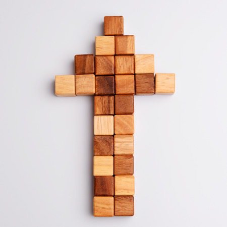 Cube or square wood block in shape of arrow in business concept about direction, top view on gray background. の写真素材