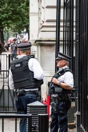 London, UK - August 18, 2015: Police officers protecting the gate of Downing street in London, the...