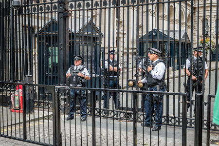 London, UK - August 18, 2015: Police officers protecting the gate of Downing street in London, the residence of the prime minister.のeditorial素材