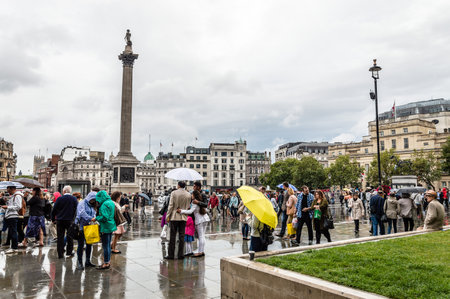 LONDON, UK - AUGUST 24, 2015: Crowd in Trafalgar Square a rainy day of summer. Trafalgar Square is a public square thatcommemorates the Battle of Trafalgar,のeditorial素材