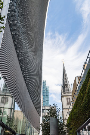 LONDON, UK - AUGUST 21, 2015:  London street in the financial district showing the contrast betwenen new buildings and old ones. Low angle view against a blue sky dayのeditorial素材