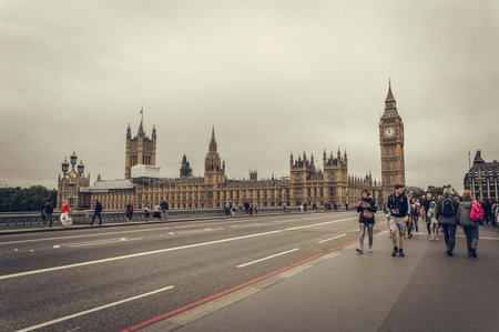 London, UK - August 18, 2015: Big Ben and Parliament Houses from Westminster Bridge a cloudy day of summer while some tourist are walking on the bridge.  London is one of the most visited cities in the world.のeditorial素材