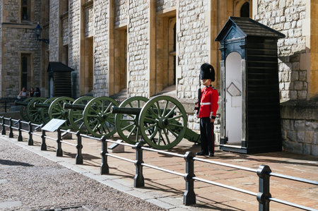 LONDON, UK - AUGUST 21, 2015:  Queen's Guard and guns - Tower of London. The Queen's Guard is the contingents of infantry and cavalry soldiers charged with guarding the official royal residences in the United Kingdom.のeditorial素材