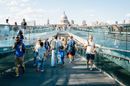 LONDON, UK - AUGUST 22, 2015: People walking over Millennium bridge a sunny day. St Pauls Cathedral in the background.のeditorial素材