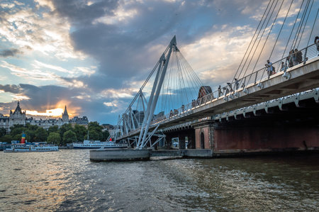 LONDON, UK - AUGUST 22, 2015: London Eye and Hungerford Bridge and Golden Jubilee Bridges from the river at sunsetのeditorial素材