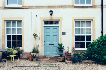 Cirencester, UK - August 18, 2015: English town house entrance with front courtyard and a painted closed doorのeditorial素材