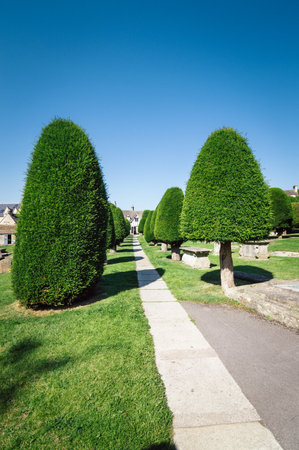 Painswick, UK - August 17, 2015: St Mary's Church and churchyard a blue sky day. Painswick is a town in the Cotswolds, originally the town grew on the wool trade.のeditorial素材