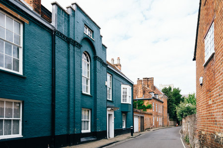 Street in the center of an old english city a cloudy day with colorful brick buildings.のeditorial素材