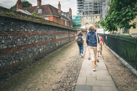 Family walking together on an old english city in a overcast day. Rear view.のeditorial素材