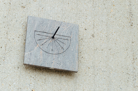 Old fashioned marble sundial clock on a concrete wall of a museumの写真素材