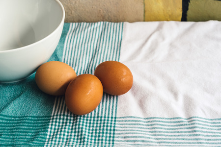 Three Fresh eggs on tablecloth. Ingredients for a homemade cakeの写真素材