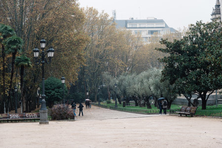Madrid, Spain - November 20, 2016: Rainy day in Spain Square of Madrid. People walking in the parkのeditorial素材