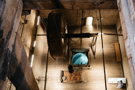 Mechelen, Belgium - July 30, 2016: Bells mechanism of Cathedral of Mechelen. Some of  the original carillon's set of 49 bells are still in working order. The flat-topped silhouette of the cathedral's tower is easily recognizable.のeditorial素材