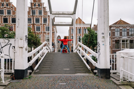 Haarlem, Netherlands - August 3, 2016: Picturesque landscape with beautiful traditional houses and prople crossing the bridge over canal of Haarlemのeditorial素材