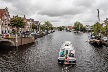Haarlem, Netherlands - August 3, 2016: Picturesque cityscape with beautiful traditional houses and vessels in canal of Haarlemのeditorial素材