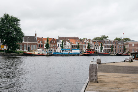 Haarlem, Netherlands - August 3, 2016: Picturesque cityscape with beautiful traditional houses and vessels in canal of Haarlemのeditorial素材