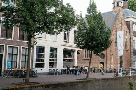 Delft, Netherlands - August 3, 2016: Cityscape of Delft with picturesque buildings, bridge, canals...