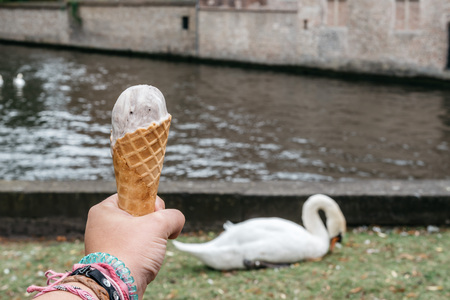 Woman holding an ice cream against medieval cityscape in Bruges, Belgium. Copyspaceの写真素材