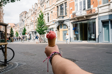 Woman holding an ice cream against medieval cityscape in Louven, Belgium.の写真素材