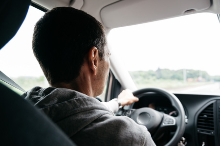 Man driving his car on the freeway. Focus on headの写真素材
