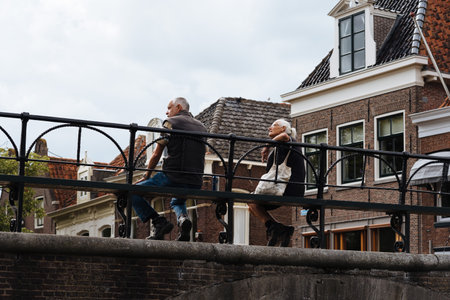 Monnickendam, Netherlands - August 08, 2016. Unidentified people sitting on bridge over the canal of traditional dutch village of Monnickendam. The town was founded by monks and it is a small fishing village today,のeditorial素材