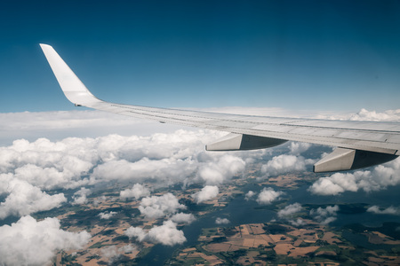 Wing of an airplane flying above the cloudsの写真素材