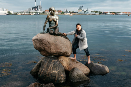Copenhagen, Denmark - August 11, 2016: Some unidentified tourists trying to climb to little mermaid statue in Copenhagen, Denmark. Evening in summerのeditorial素材