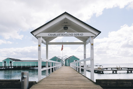 Copenhagen, Denmark - August 11, 2016. Private deck for swimming in the baltic coast of Copenhagen with cute green housesのeditorial素材