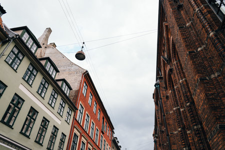Copenhagen, Denmark - August 11, 2016. Low angle view of residential buildings and church in historical city centre of Copenhagen a cloudy day of summerのeditorial素材