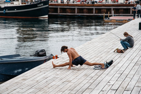 Copenhagen, Denmark - August 12, 2016: Man practicing yoga outdoors in the pier of the harbor of Copenhagenのeditorial素材
