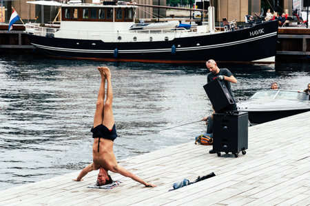 Copenhagen, Denmark - August 12, 2016: Man practicing yoga outdoors in the pier of the harbor of Copenhagenのeditorial素材