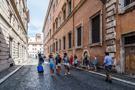 Rome, Italy - August 18, 2016: Tourists in traditional street in the historical centre of Rome. Sunny summer dayのeditorial素材