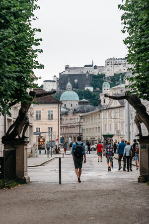 Salzburg, Austria - August 6, 2017: Scenic cityscape of Salzburg with tourists against castle. The Old Town of Salzburg is internationally renowned for its baroque architecture and was listed as a UNESCO World Heritage Site.のeditorial素材
