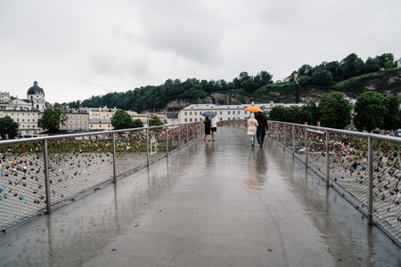 Salzburg, Austria - August 6, 2017: Scenic view of bridge with padlocks over river in Salzburg. The Old Town of Salzburg is internationally renowned for its baroque architecture and was listed as a UNESCO World Heritage Site.のeditorial素材