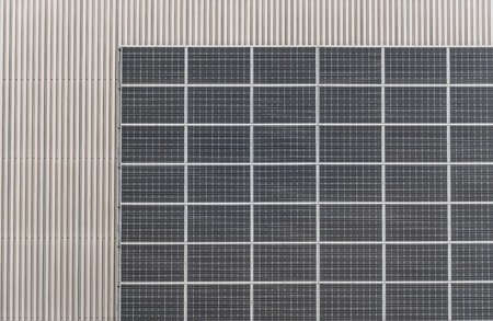 Photovoltaic panels on industrial metal facade of building.