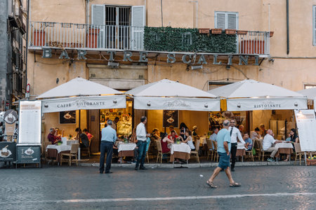 Sidewalk restaurant with tourists in Roman square a sunny summerのeditorial素材