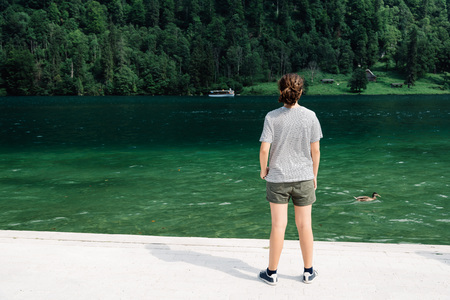 Young woman standing by beautiful lakeの写真素材