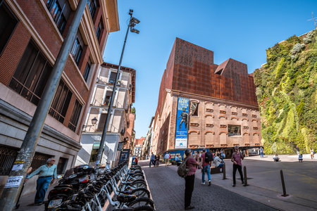 Madrid, Spain - October 14, 2017: Outdoors view of CaixaForum Madrid is a museum and cultural center in Paseo del Prado sponsored by La Caixa Bank. On the house next to it, there is a green wallのeditorial素材