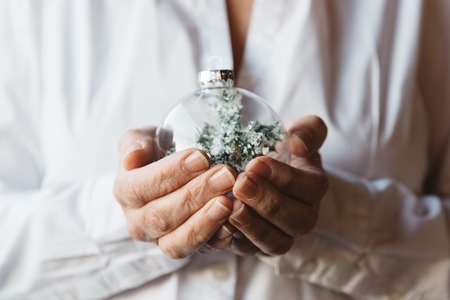 Close-up of woman hands holding Christmas baubleの写真素材