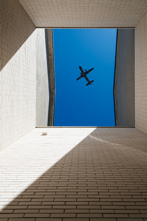 Plane flying above buildingの写真素材