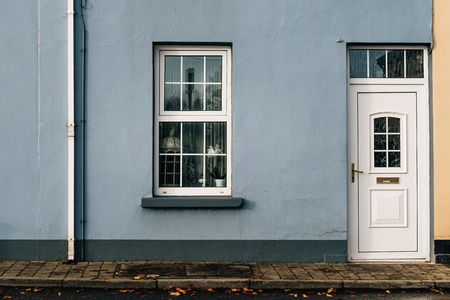 Entrance to old house with white door and window on blue paintedの写真素材