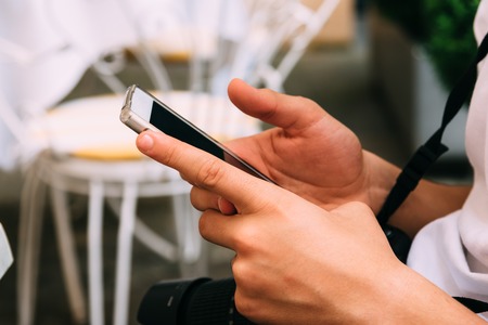 Close up of young adult texting on smart phone