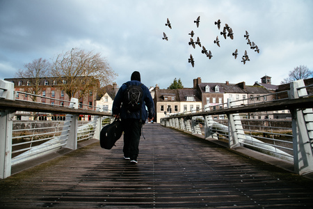 Beggar crossing a bridge in Cork