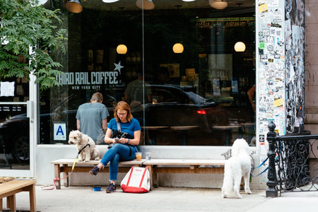 Unidentified woman with dog sitting at cafe in Stuyvesant Streetのeditorial素材