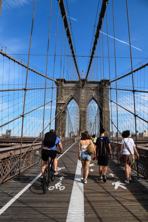 People walking and cycling in promenade over Brooklyn Bridgeのeditorial素材
