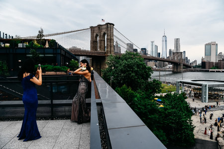 Women taking photos in rooftop against skyline of New Yorkのeditorial素材